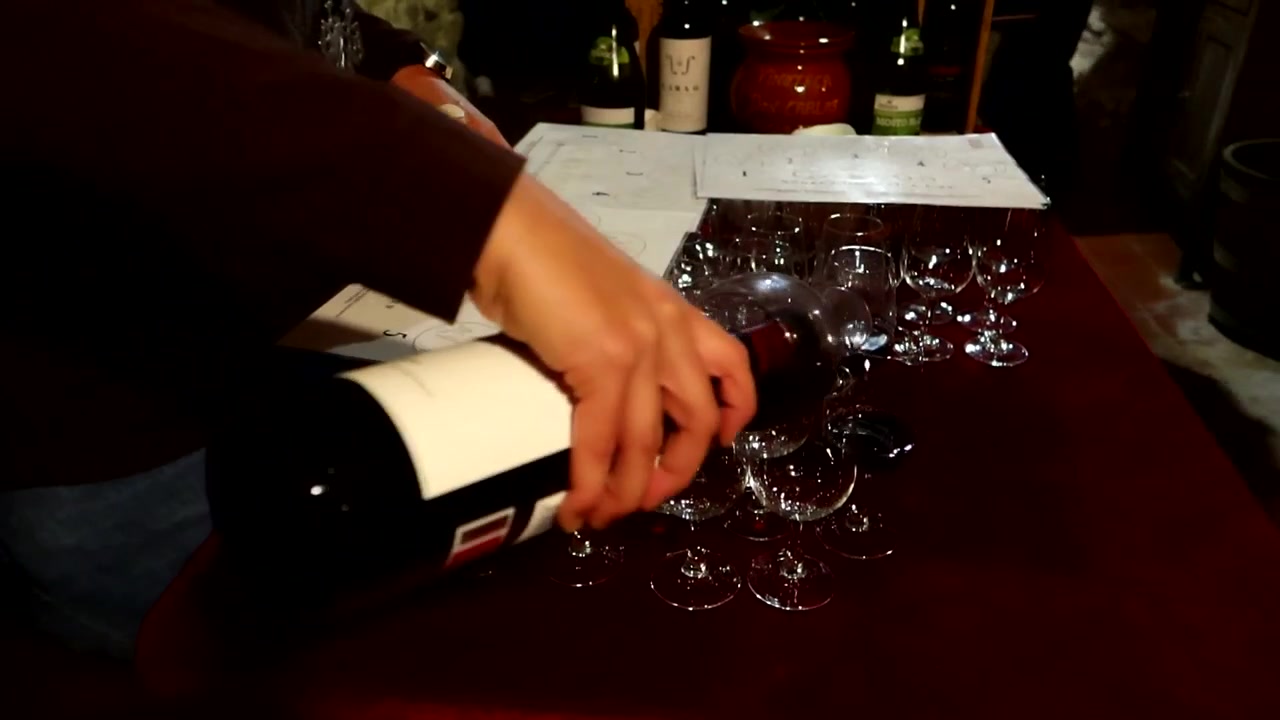 Donna che serve un vino rosso invecchiato in bicchieri per una degustazione di vino in cantina.
