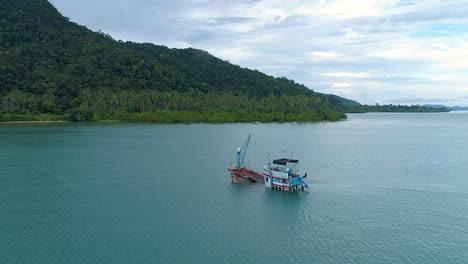 drone dando vueltas alrededor de un barco medio hundido en el mar
