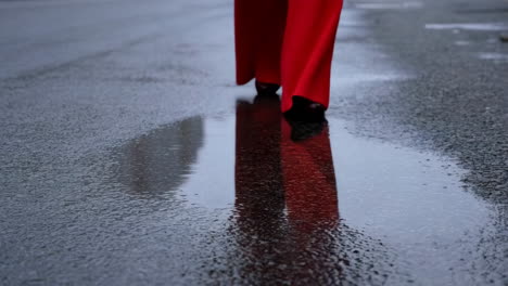 person with red pants reflected on wet ground