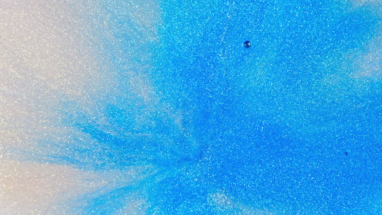 생동감 넘치는 파란색 잉크가 은 물에서 창하여 추상적인 확산 패턴을 만들고, 높은 각도 촬영