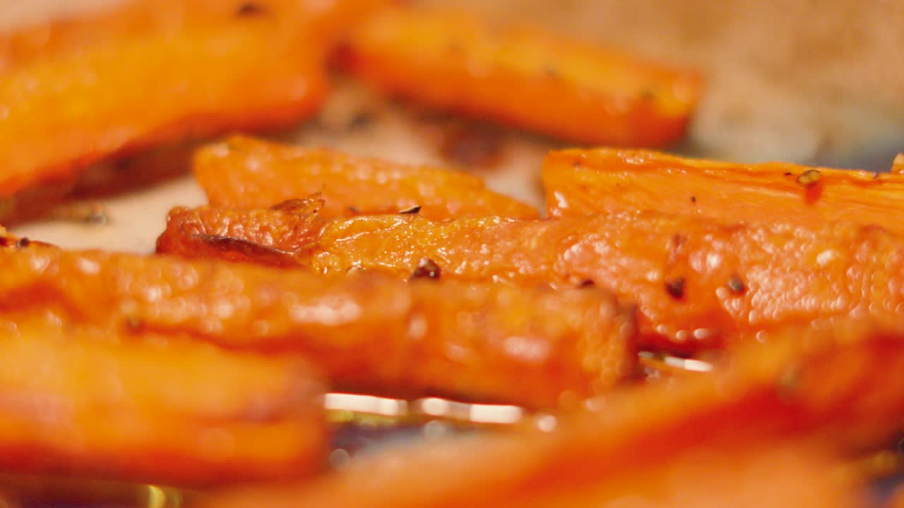 Elegant Pan Across Freshly Cooked Carrots Roasted in Hot Oven Seasoned with Pepper. Side Dish to Roast Sunday Dinner. Classic British Cuisine Food