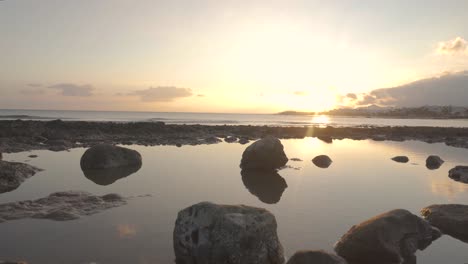 puesta de sol sobre la costa rocosa