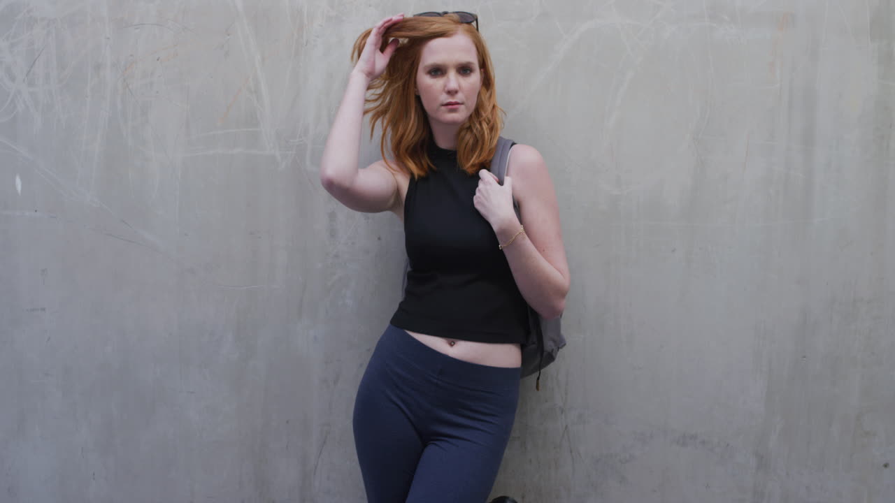 retrato atractiva mujer joven de cabello rojo sonriendo feliz corriendo mano a través del cabello mirando confiado disfrutando del estilo de vida