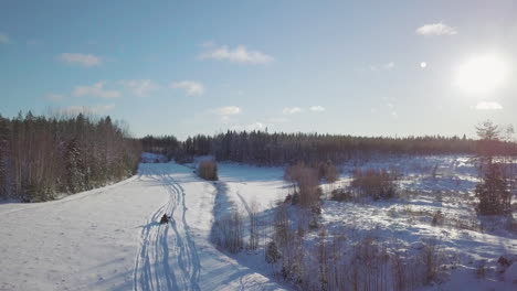 person driving away in atv on extreme winter terrain in aerial view