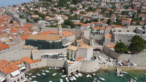 Aerial-drone-shot-of-Dubrovnik-Cathedral-in-repair-with-old-port-in-Croatia-sunrise-hour