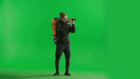 photographer with backpack on green screen