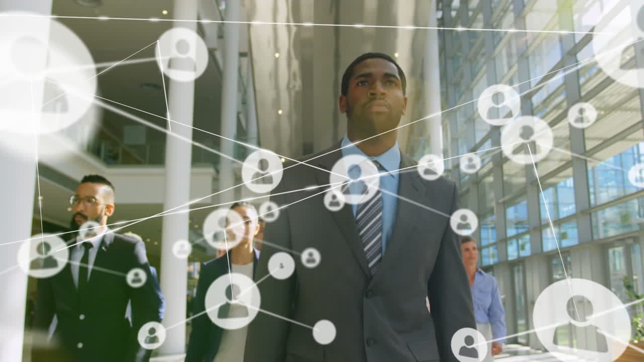 Animation of network of connections with icons over diverse business people working at office
