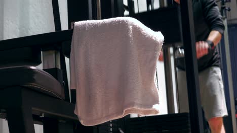 wet sweaty towel dripping, fitness athlete trains in generic gym in background