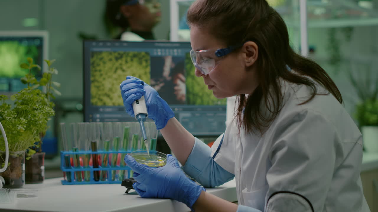 Scientist woman taking genetic solution from test tube with micropipette
