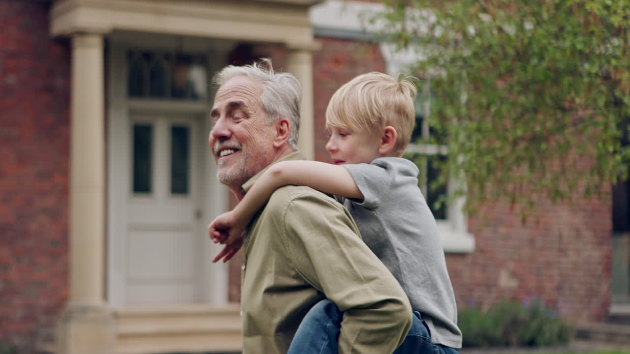Grandfather giving grandson a piggyback ride in the garden