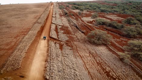 aerial over a pickup truck driving on a dirt road on molokai hawaii from maunaloa to hale o lono 1