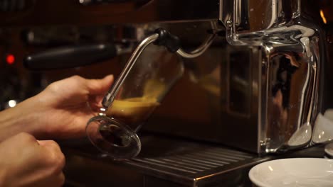 máquina de café prepara espresso en café de vidrio largo - primer plano