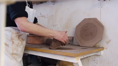 Close-Up-Of-Male-Potter-Rolling-Out-Lump-Of-Clay-In-Ceramics-Studio