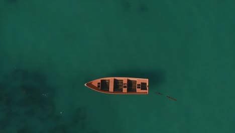 Aerial-up-above-boat-among-azure-water-and-coral-reefs