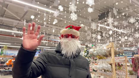 a man in a santa claus mask waves his hand while looking at the camera a man in a santa claus mask waves his hand while looking at the camera new year and christmas 2023 concept