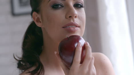 sensual pretty young woman holding red apple