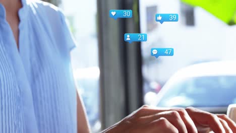 burbuja de habla con iconos digitales con números crecientes contra la mujer caucásica que usa portátil