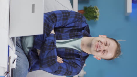 vertical video of home office worker man makes a trust sign to the camera.