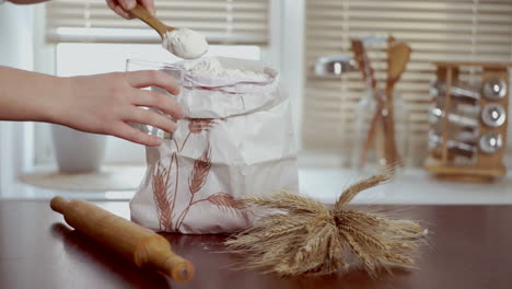 home baking ingredients. chef puts flour in glass. home baking ingredients