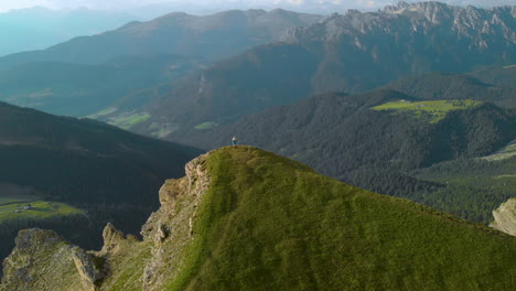 aerial view rising above hiker on seceda mountain overlooking idyllic south tyrol vibrant valley scenery into top down shot