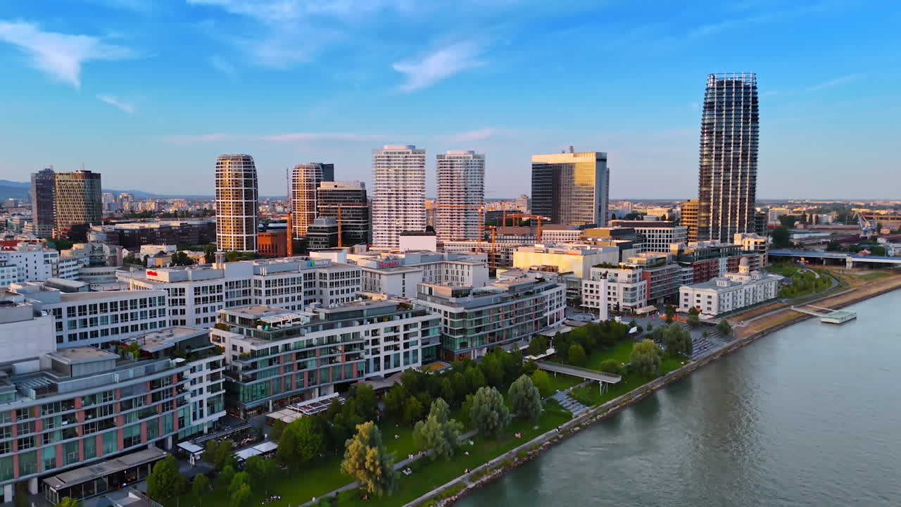 Bratislava, Slovakia, 2 June 2025: Bratislava riverside skyline. A vibrant cityscape of Bratislava showcases modern architecture along the river as the sun sets in the evening sky