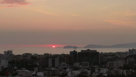 golden horizon over pacific ocean from miraflores, lima, peru - aerial dolly in