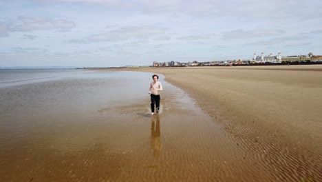 Adult-male-running-along-the-water’s-edge-making-splashes-as-he-goes