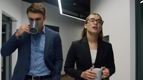 Workers-walking-office-hallway-on-lunch-break.-Friendly-company-employees-talk