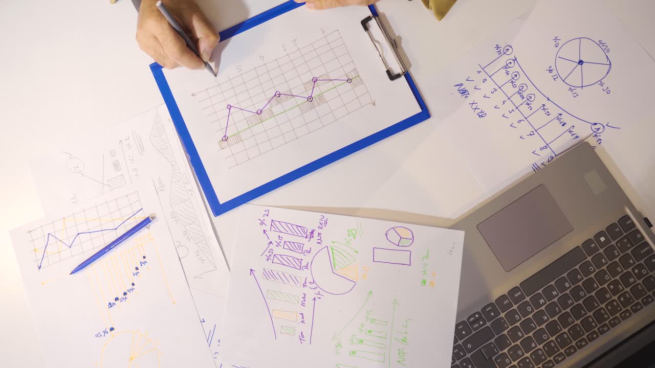 la mano masculina dibuja gráficos de negocios en un papel blanco.