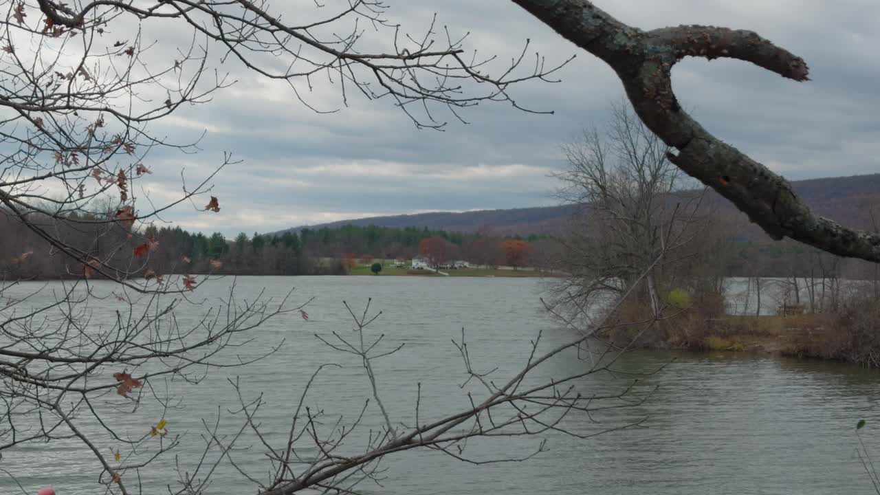 A large beautiful white house that sits on a lake in the mountains