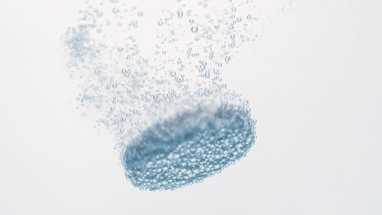 Extreme Close-up effervescent tablet, pill bubbling underwater. Shot on super slow motion camera 1000 fps