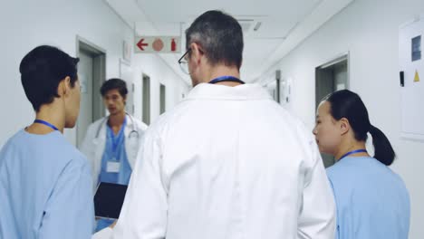 three doctors walking in corridor talking 4k