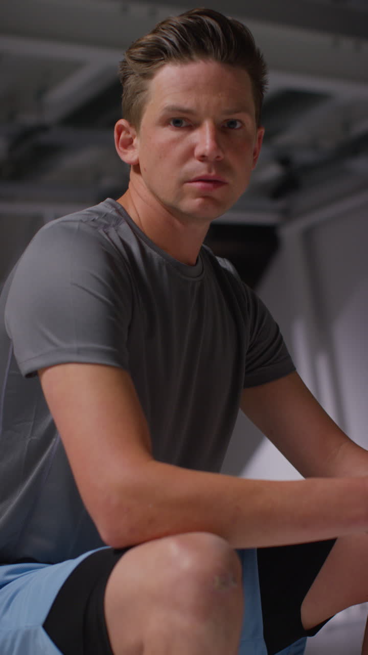 Vertical Video Portrait Of Determined Male Athlete Sport Training In Gym Sitting And Concentrating In Changing Room With Focused Expression 3