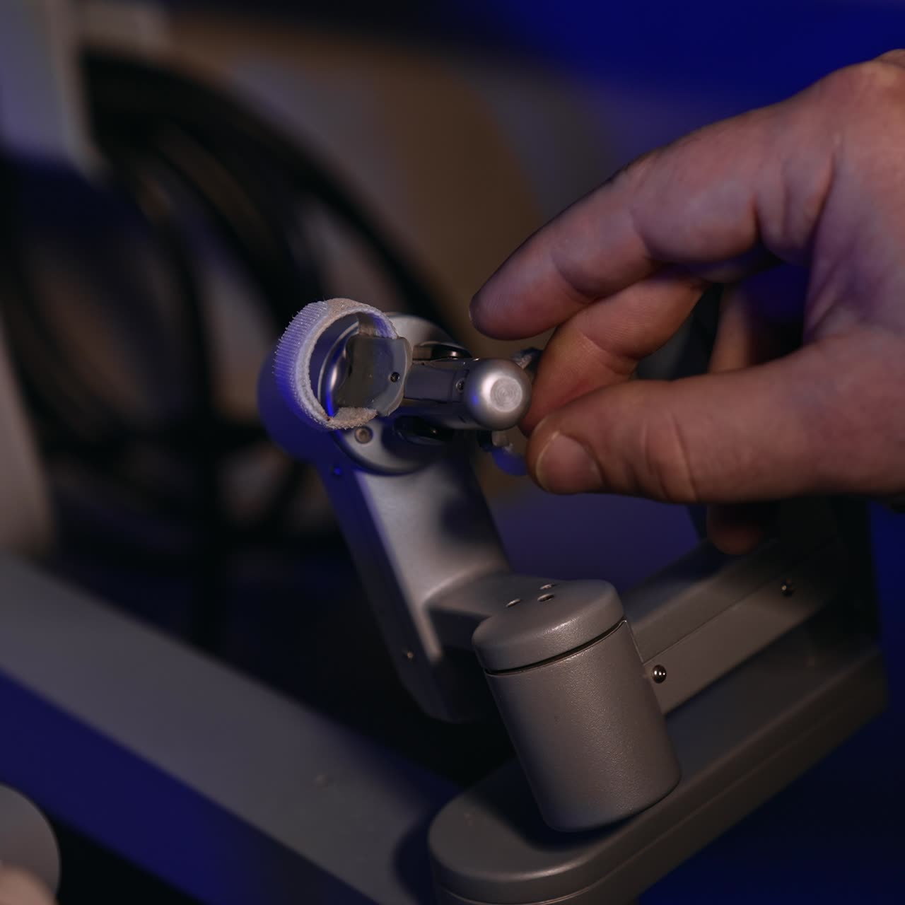 Male hand moving the sensitive rotating handle of a robotic equipment in surgery room. Surgical robot operating by human. Close up