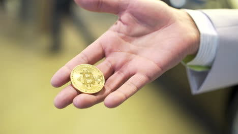 mano con una moneda de bitcoin