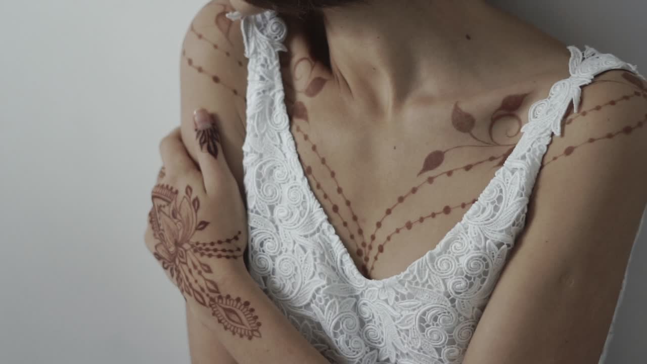 Mujer con un tatuaje de henna y vestido de encaje