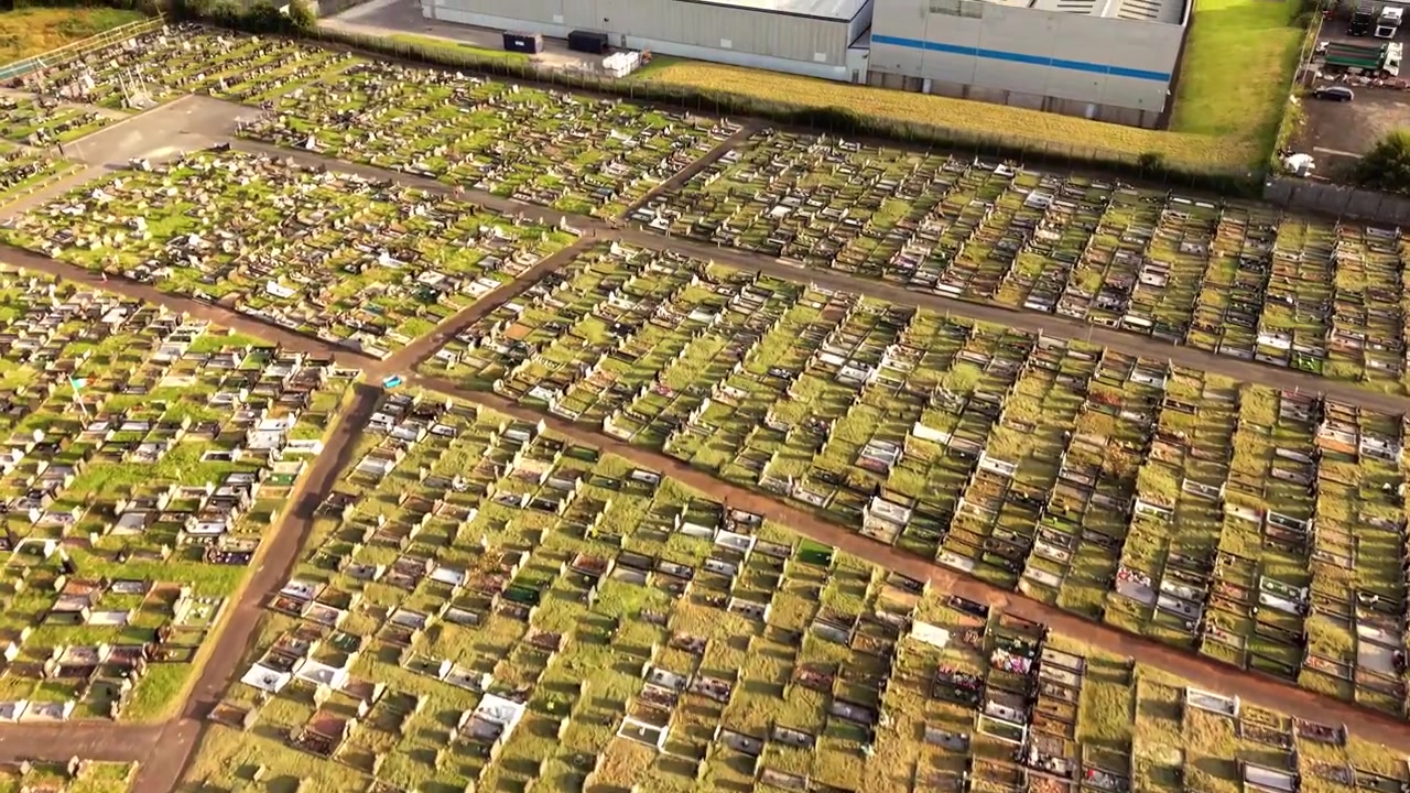 Opkomende 4K 60FPS luchtopname van Milltown Cemetery en het Ierse Republikeinse Perceel aan de Falls Road in Belfast, Noord-Ierland, VK. Geproduceerd met uitzendklare Rec709-kleur.