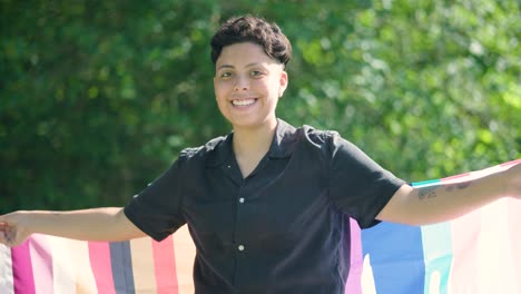 mujer lesbiana ondea con orgullo la bandera del orgullo gay del arco iris al sol