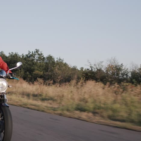 a young man rides a motorbike along corn fields 3