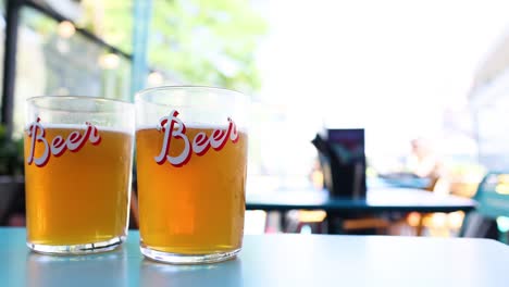 two beer glasses on a table outdoors