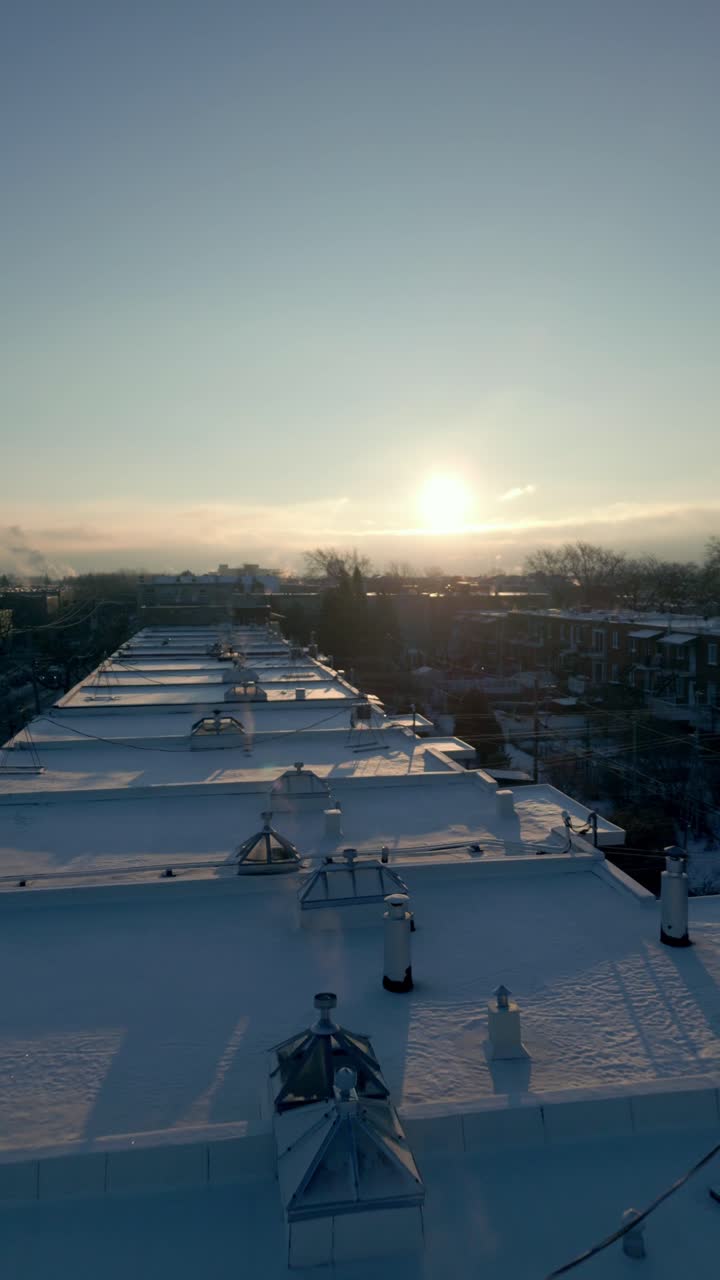 Vertical drone pullback across rootops of Montreal neighborhood Vieux Rosemont in the winter, urban neighborhood