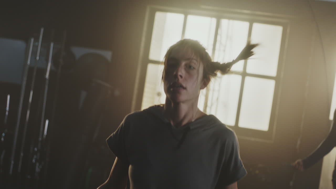 женщина прыгает по веревке в тренажерном зале