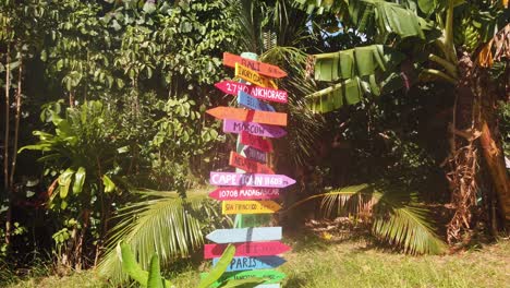 gimbal booming up shot of a colorful artistic sign with travel distances to various locations around the world from kaua'i on a cacao farm in hawai'i