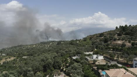 arson causes forest fire smoking in the distance, andalucia, spain