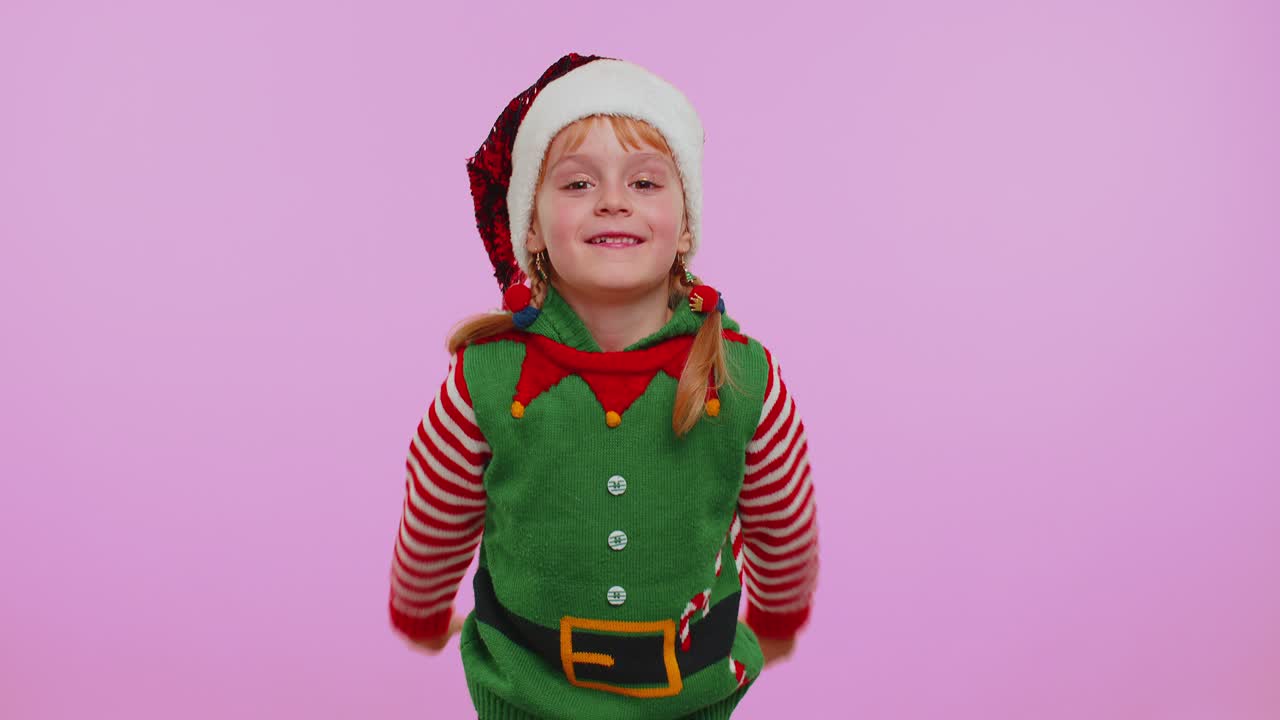 Bláznivá dívka v Santa vánočním kostýmu vyplazuje jazyk a dělá hloupé obličeje