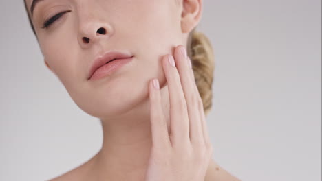 beauty portrait of woman touching beautiful face slow motion skincare concept on a grey background slow motion red epic dragon