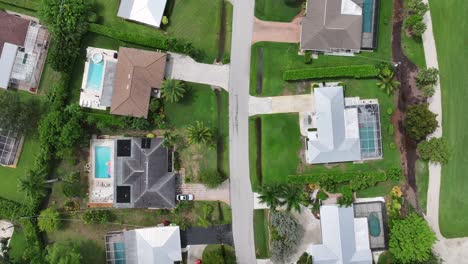 mansions and villas with swimming pool during sunny day in upscale neighborhood