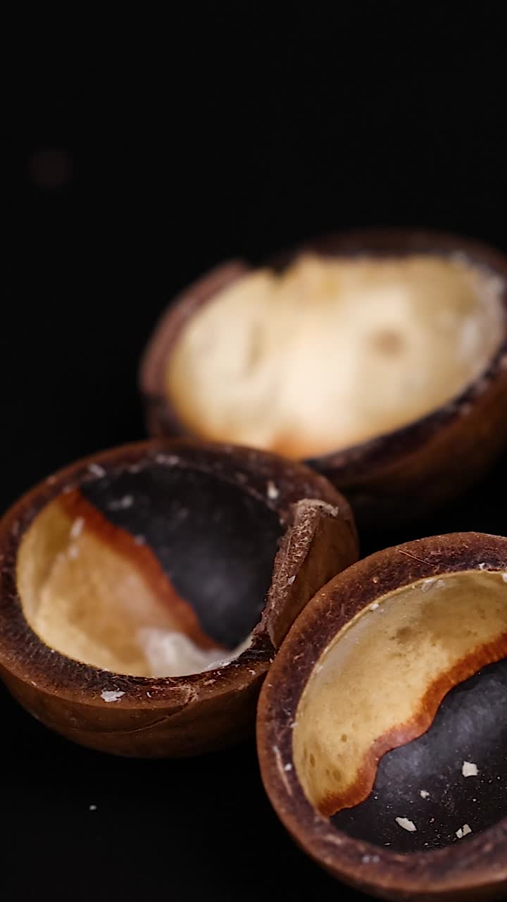 Noci di macadamia disposte su uno sfondo scuro