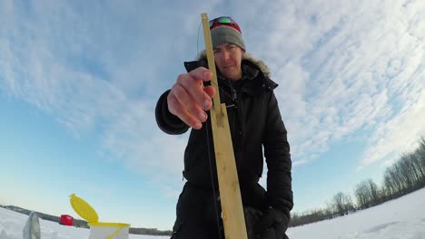 ice fisherman setting up the bait for fishing