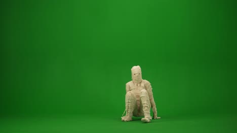 scary mummy wrapped in bandages break dancing spinning on the floor green screen isolated chroma key